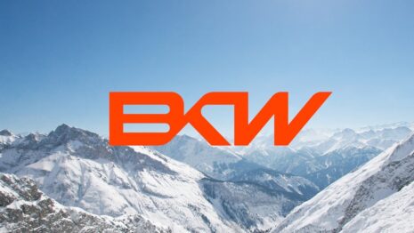 Oranges BKW Logo vor verschneiter Berglandschaft unter blauem Himmel