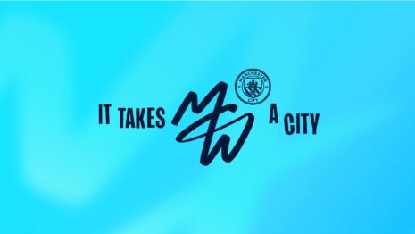 Hellblauer Farbverlauf mit dem Schriftzug It takes a city, dem MCW-Monogramm in Dunkelblau und dem Wappen von Manchester City