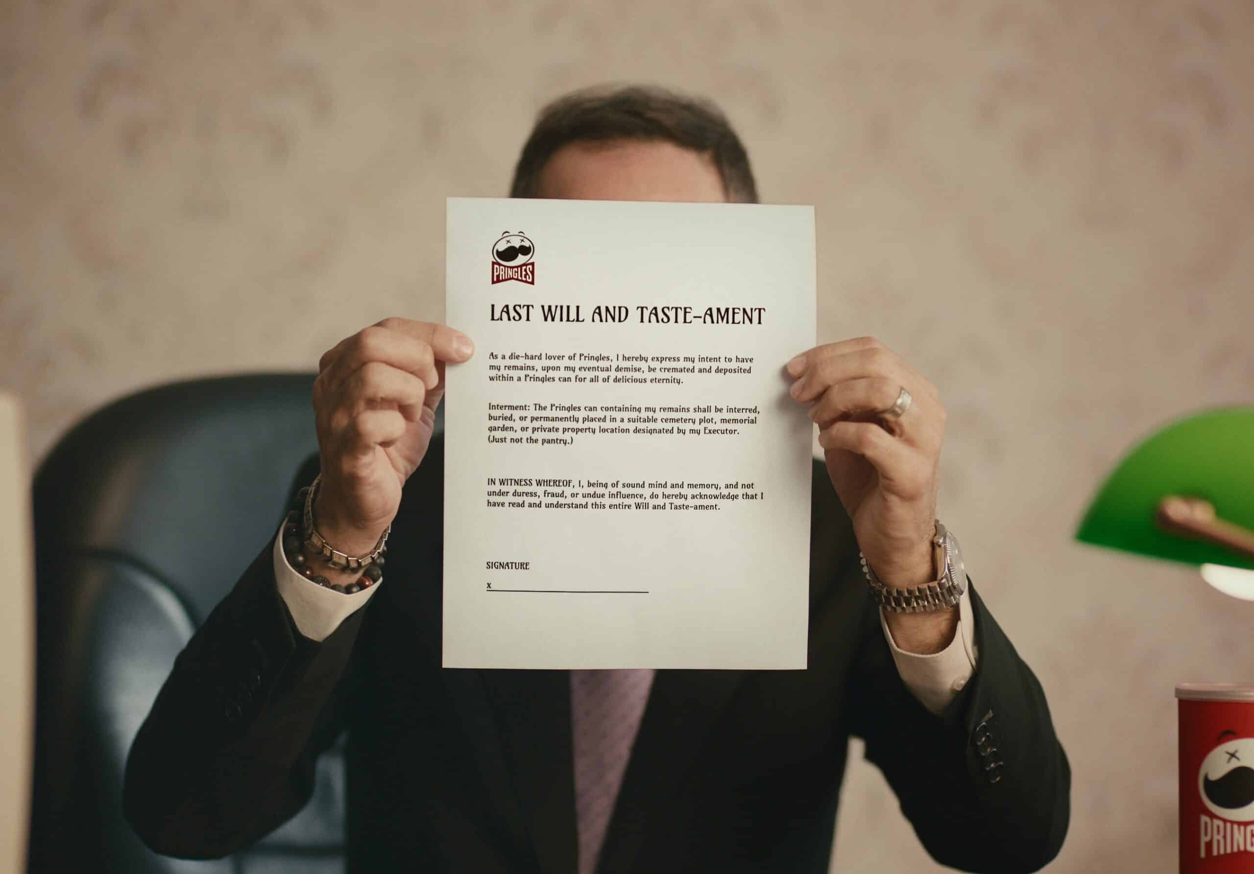 Person hält das Dokument Last Will and Taste-ament mit Pringles-Logo vor sich